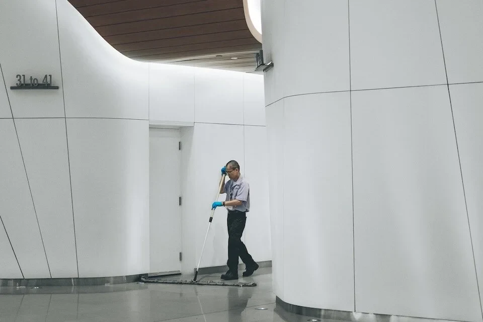 A commercial cleaner caring for the floor of a bright shared hallway